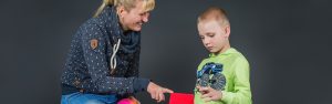 Die Schulbegleitung zeigt einem Jungen etwas